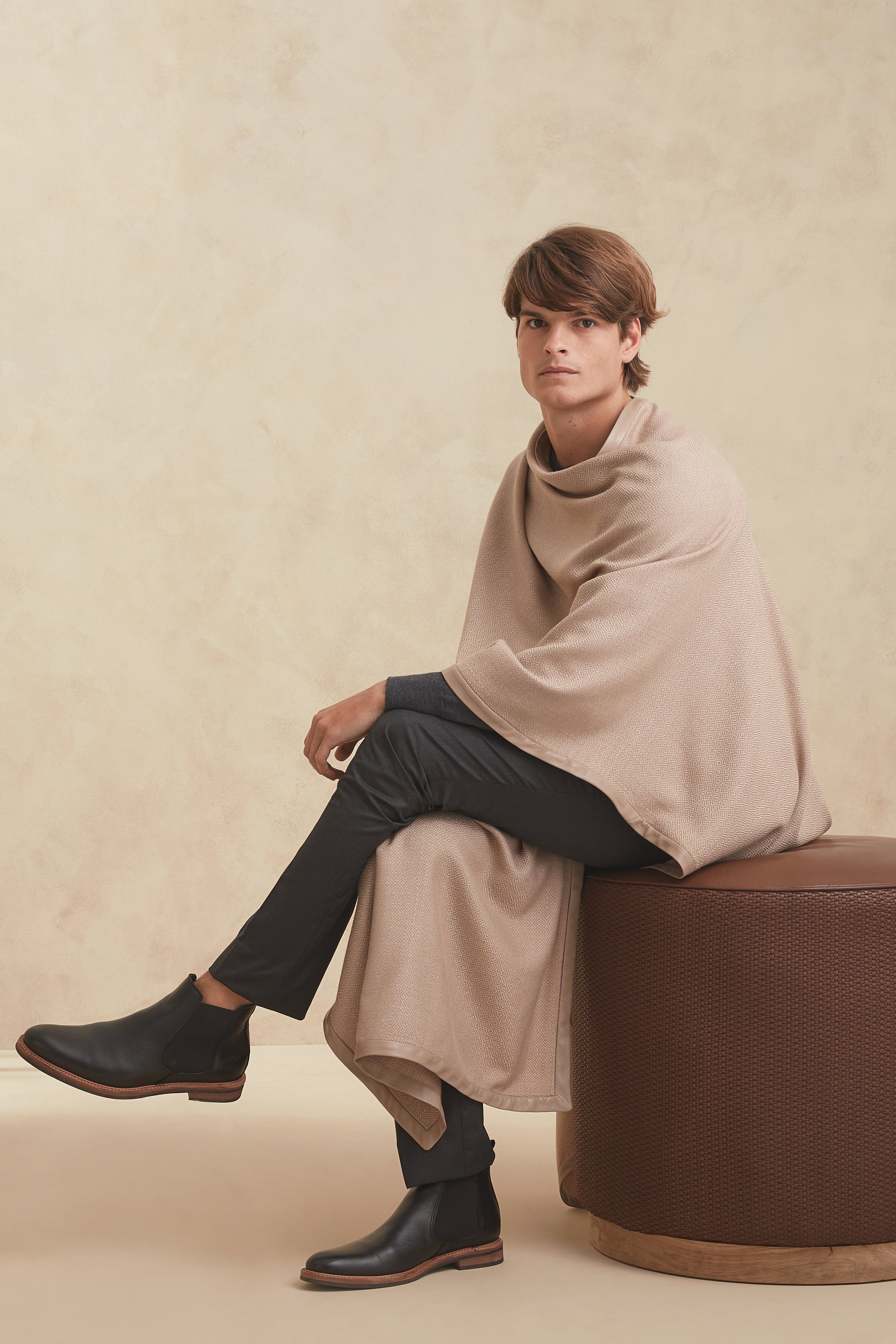 Hand-loomed cape for men in superfine merino wool and camel fiber, herringbone pattern with Argentinean leather trim.
